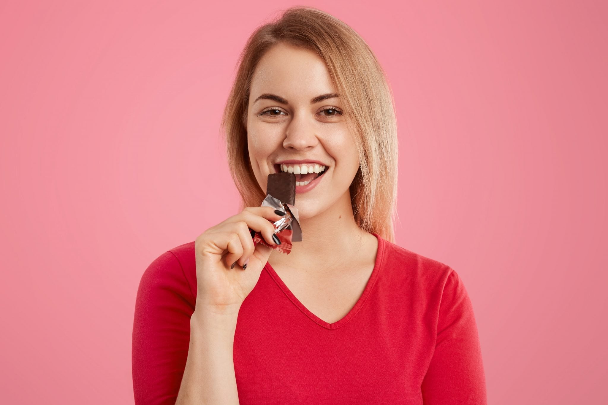photo attractive light haired european young woman eats delicious sweet chocolate being sweettooth 2048x1365 1
